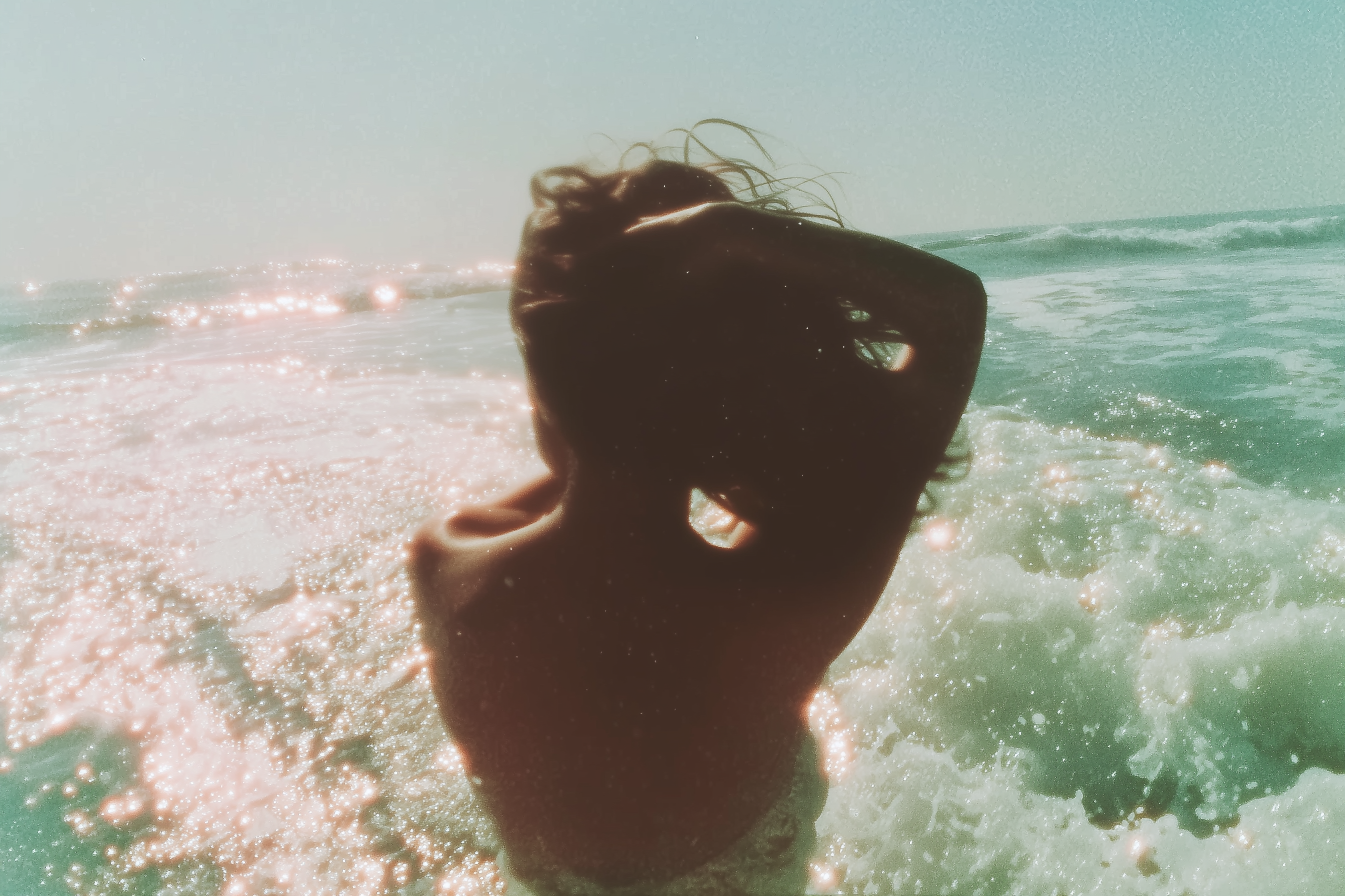 Person partially submerged in ocean water with a blurred background